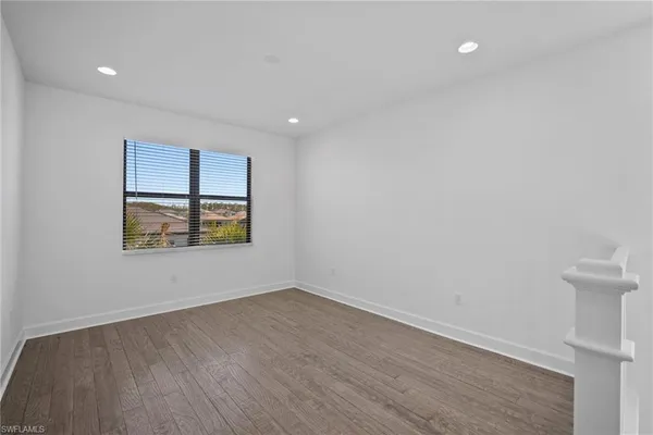 an empty room with a window and a ceiling fan