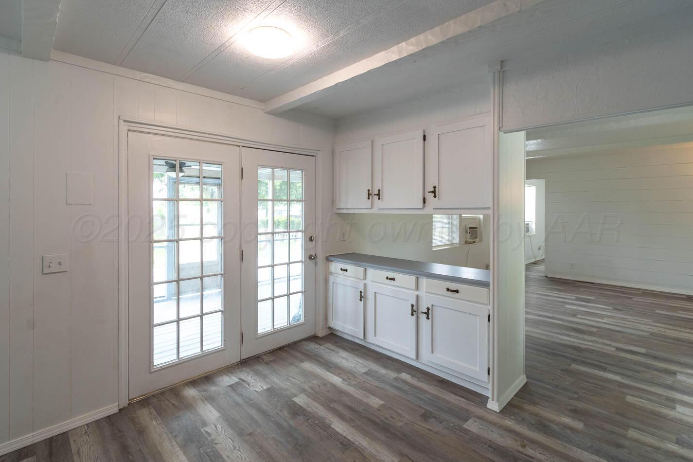 201 Michael Drive Fritch, TX 79036 - Photo 11 of 19 a kitchen with granite countertop white cabinets and wooden floor
