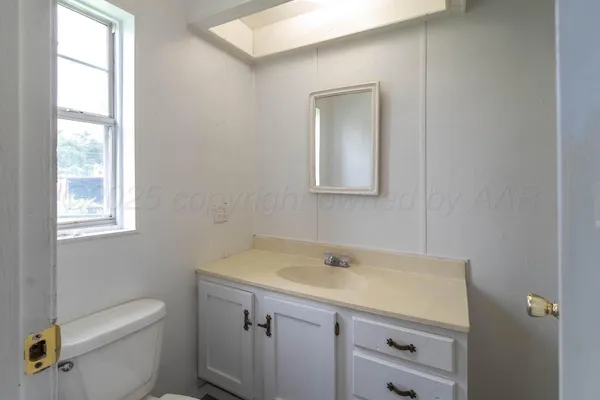 a bathroom with a sink toilet and a window