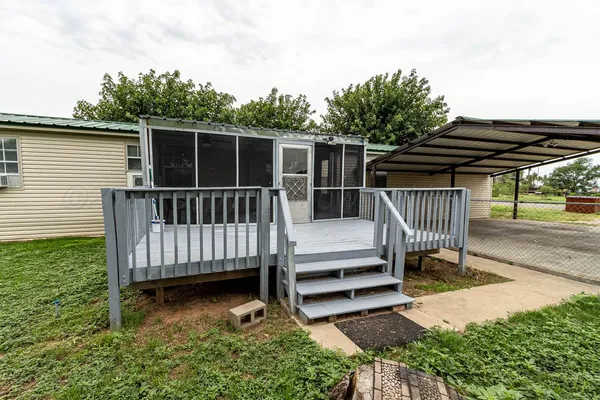 a view of backyard with deck and a garden