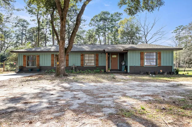 a front view of a house with a yard and potted plants