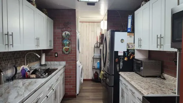 a kitchen with stainless steel appliances granite countertop a refrigerator a stove and a sink
