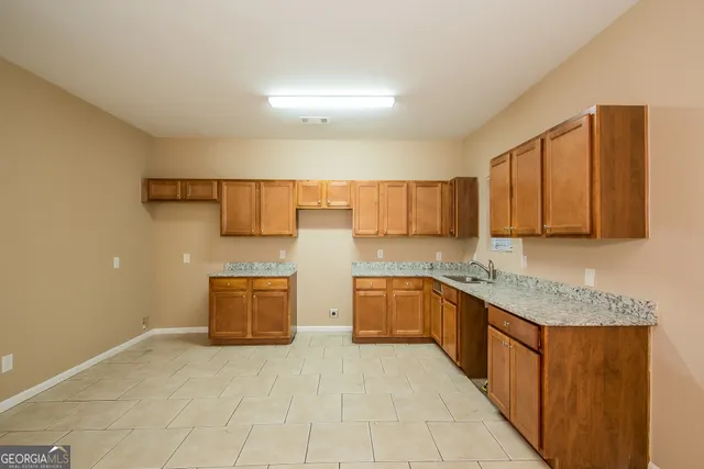 a large kitchen with stainless steel appliances granite countertop a sink stove and cabinets
