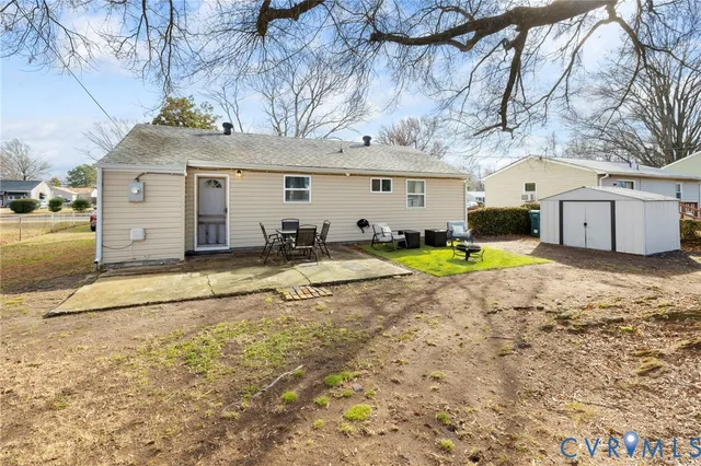 a view of a house with a yard and large tree