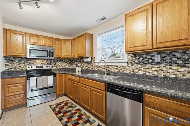 a kitchen with granite countertop a sink stainless steel appliances and cabinets