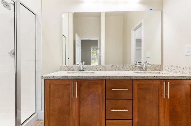 a bathroom with a granite countertop sink and a mirror