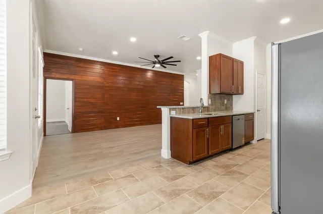 a kitchen with stainless steel appliances granite countertop a stove a sink and a refrigerator