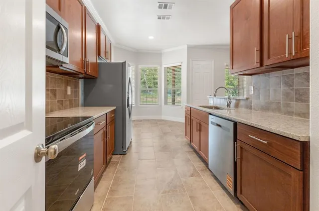 a kitchen with stainless steel appliances granite countertop a sink stove and refrigerator