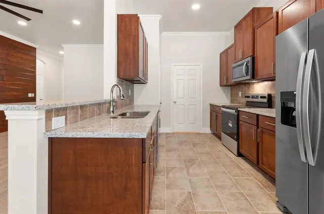 a kitchen with stainless steel appliances granite countertop a sink stove and refrigerator