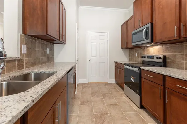 a kitchen with stainless steel appliances granite countertop a sink stove and microwave