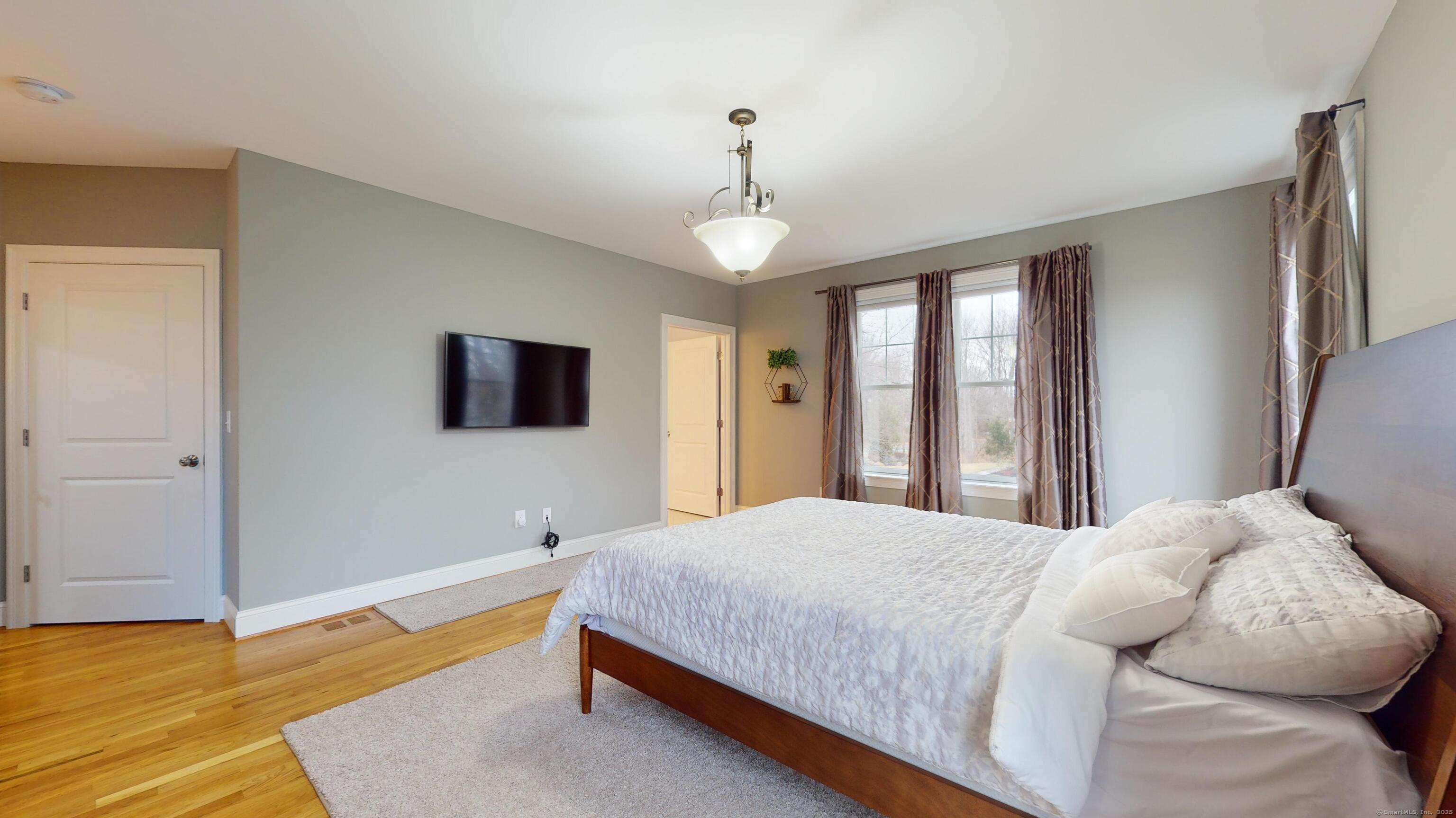 1012 Maple Street Rocky Hill, CT 06067 - Photo 14 of 31 a bedroom with a bed and a chandelier