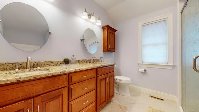 a bathroom with a granite countertop sink mirror and toilet