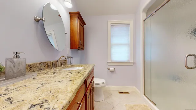 a bathroom with a sink vanity mirror and toilet