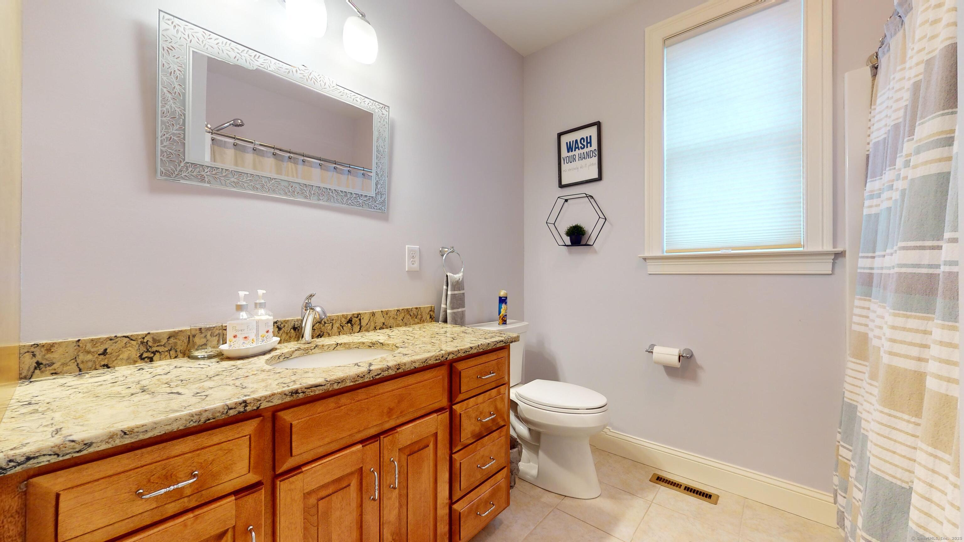 1012 Maple Street Rocky Hill, CT 06067 - Photo 20 of 31 a bathroom with a granite countertop toilet sink and mirror