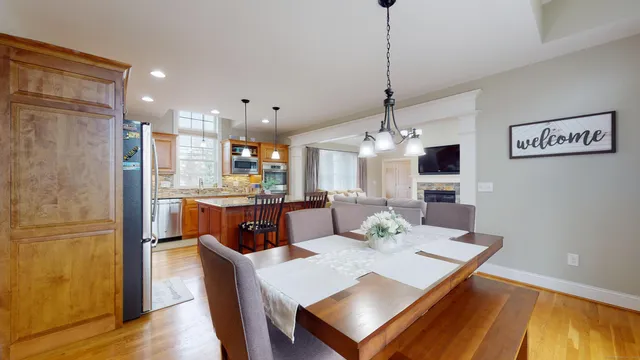 a view of a dining room and livingroom with furniture wooden floor a chandelier