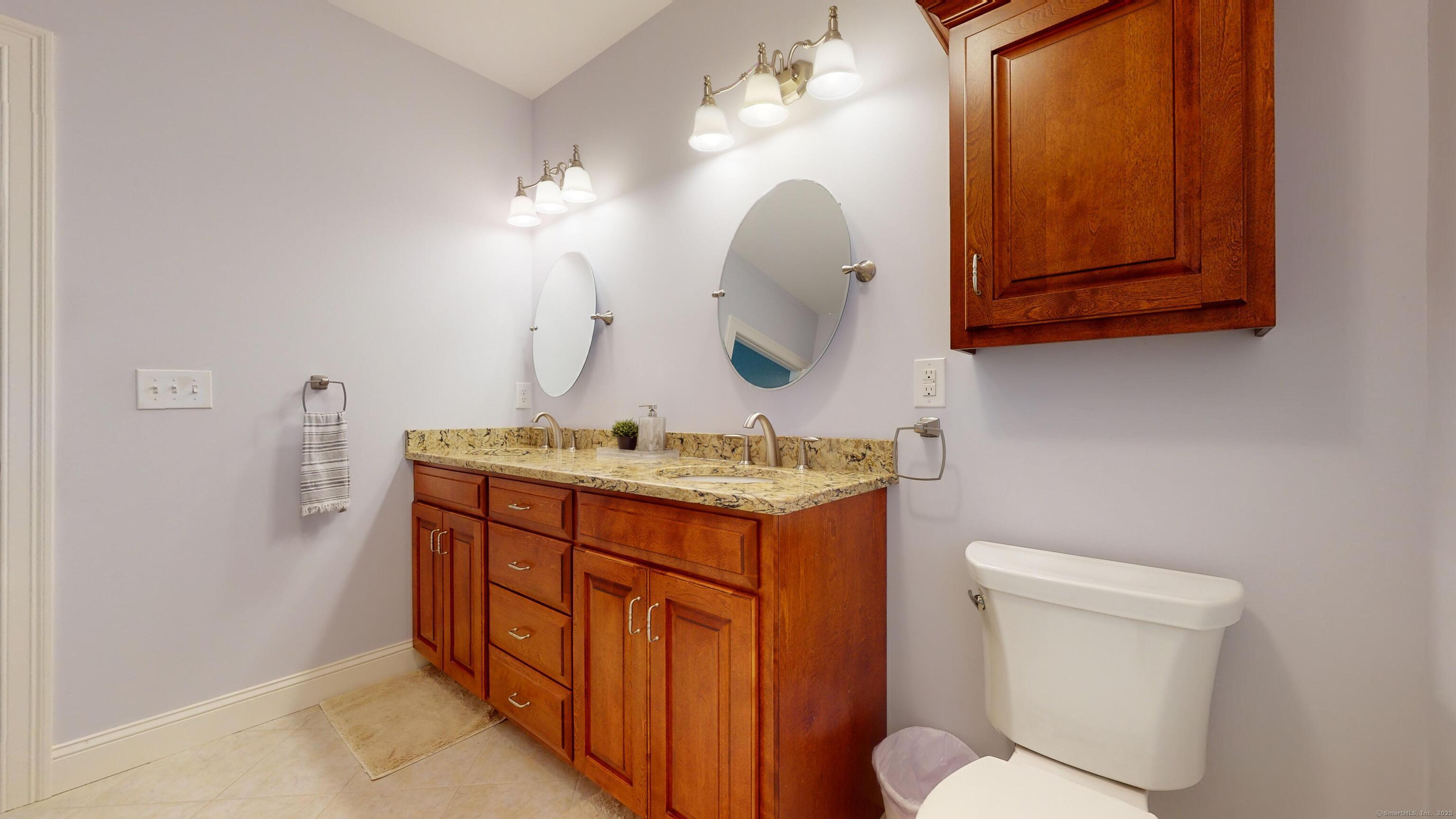 1012 Maple Street Rocky Hill, CT 06067 - Photo 24 of 31 a bathroom with a granite countertop toilet sink and mirror