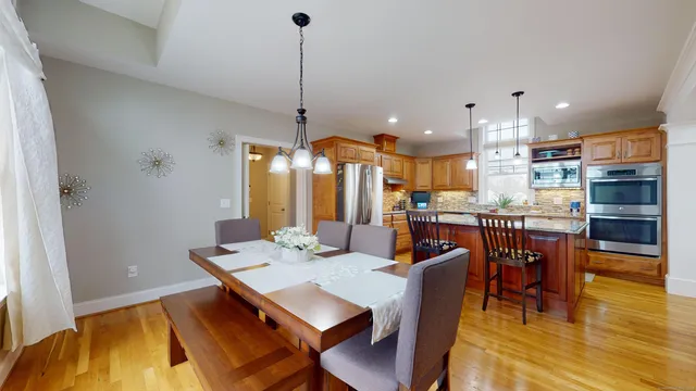 a view of a dining room and livingroom with furniture wooden floor a chandelier