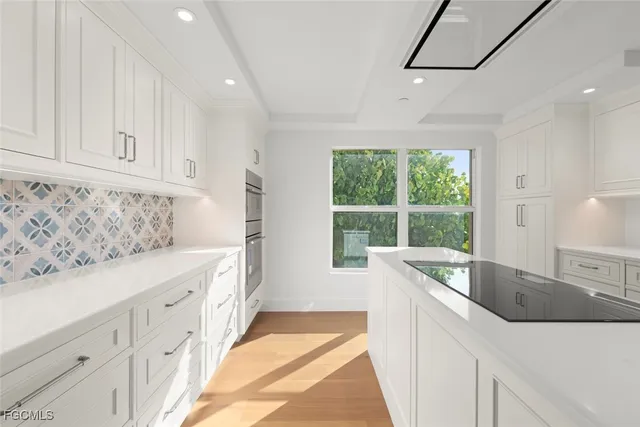 a large white kitchen with a large window