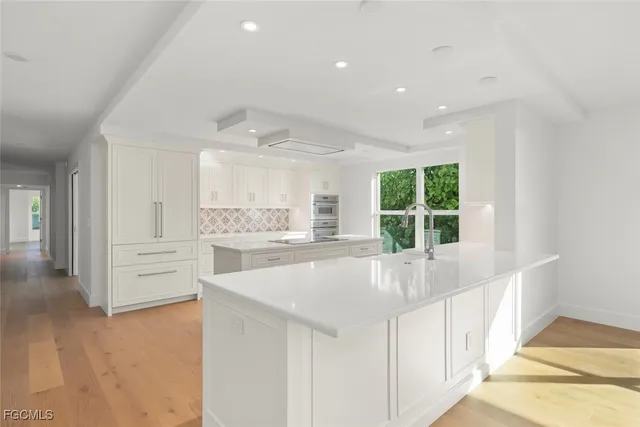 a kitchen with granite countertop a sink stainless steel appliances and cabinets
