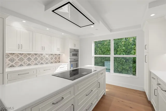 a view of a kitchen with kitchen island a sink wooden floor and a counter top space