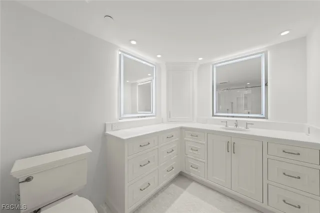 a bathroom with a shower sink vanity and toilet