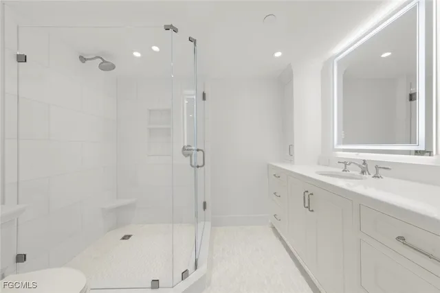 a bathroom with a granite countertop sink a toilet and shower