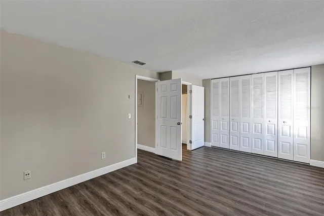 a view of an empty room with wooden floor