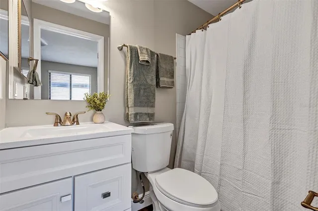 a bathroom with a toilet a sink and a mirror