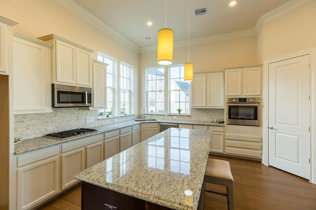 9546 London Bridge Station Houston, TX 77045 - Photo 13 of 41 Whether you go big, small, or anywhere in between, this expansive urban chef's kitchen caters to all with its ample vertical storage, integrated counter cooktop, and an impressive granite-topped island, perfectly designed to accommodate comfortable stools underneath.