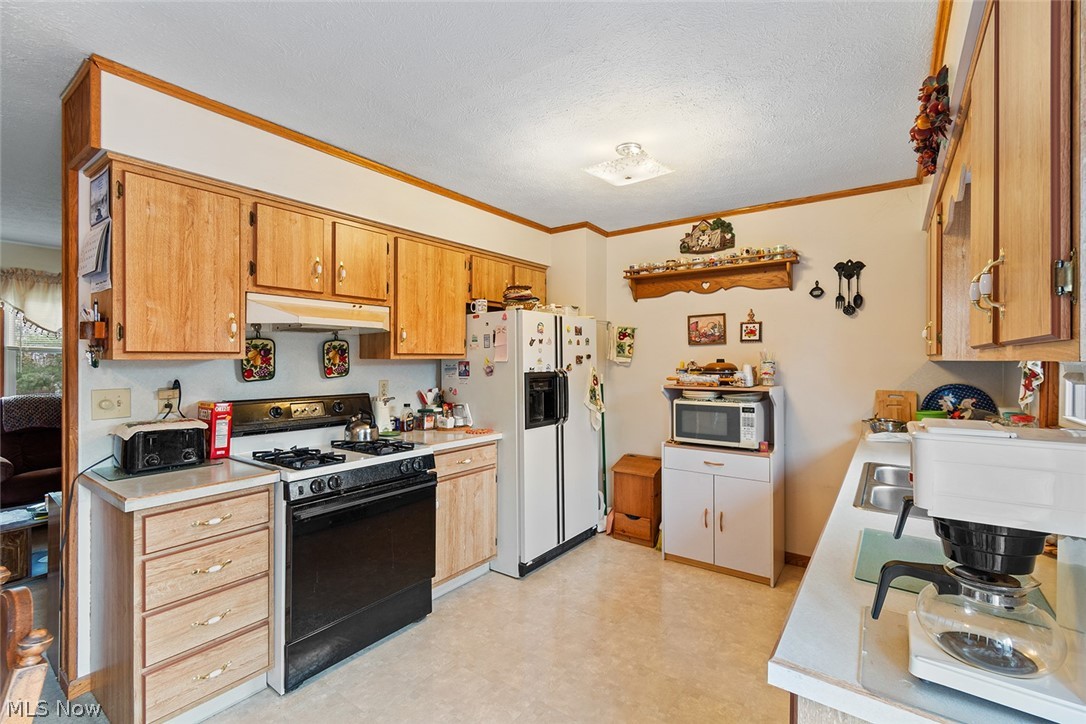 12640 Doylestown Road Rittman, OH 44270 - Photo 14 of 35 Kitchen with light tile floors, ornamental molding, white appliances, and a textured ceiling