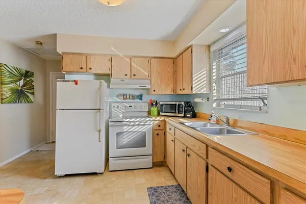 a kitchen with a refrigerator sink and cabinets