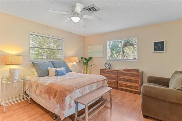 a bedroom with a bed wooden floor and window