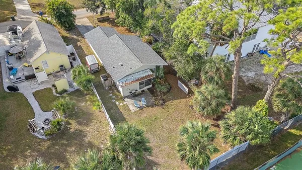 an aerial view of a house with a yard and large trees