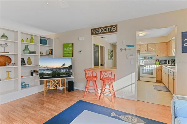 a living room with stainless steel appliances kitchen island granite countertop furniture and a wooden floor