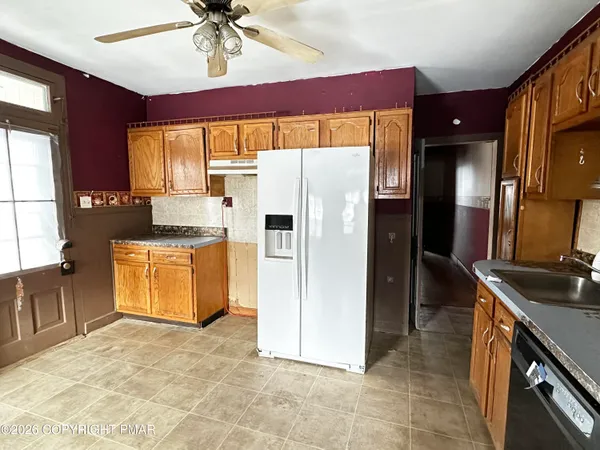a kitchen with stainless steel appliances granite countertop a refrigerator a stove and a sink