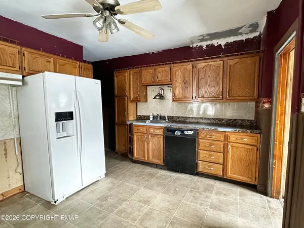 a kitchen with granite countertop a refrigerator stove top oven and sink