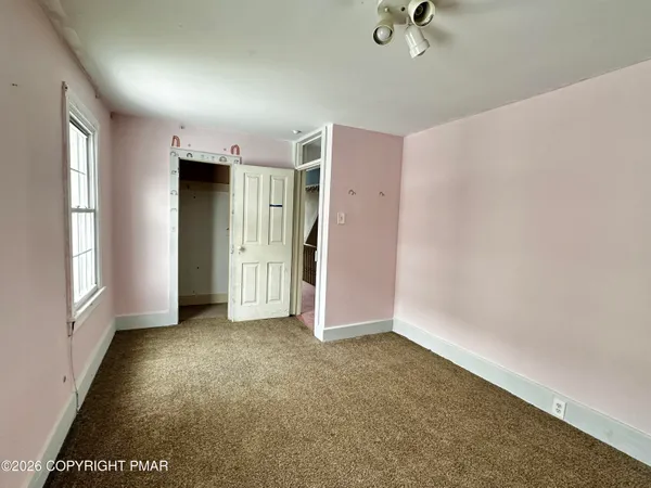 an empty room with windows and closet