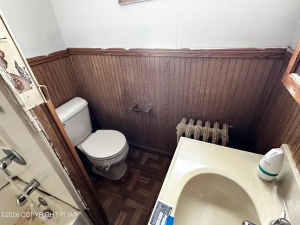 a bathroom with a toilet and a chair