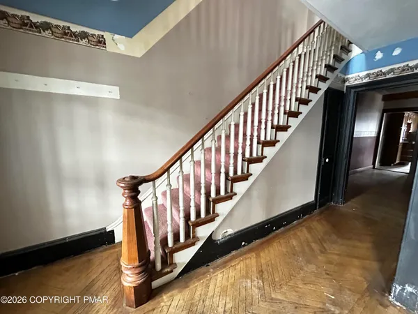 a view of staircase with lots of frames on wall and windows