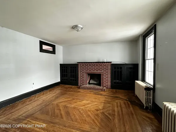 a view of empty room with wooden floor