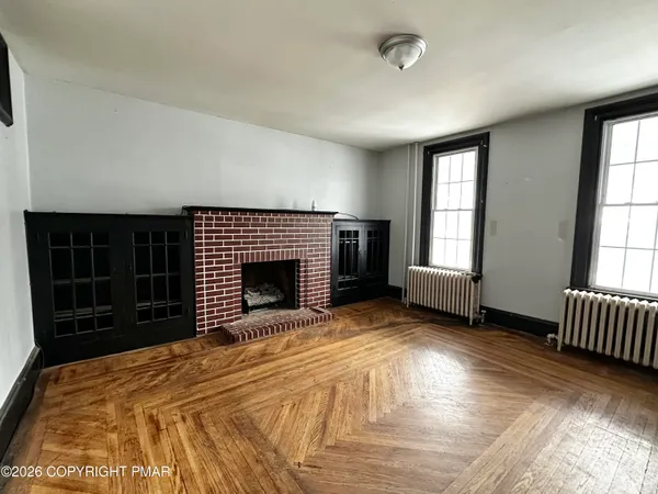 a view of an empty room with a fireplace and a window
