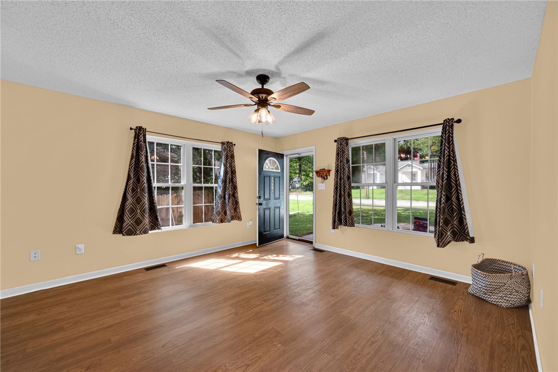 1020 Elizabeth Street Anderson, SC 29624 - Photo 6 of 22 Natural light floods this inviting living space, highlighting its warm wood floors and welcoming entrance.