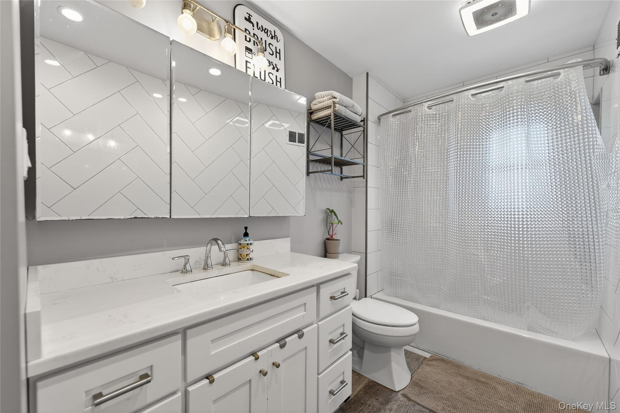 3530 Long Beach Road, Unit 8 Oceanside, NY 11572 - Photo 14 of 19 a bathroom with a sink a toilet and a large mirror