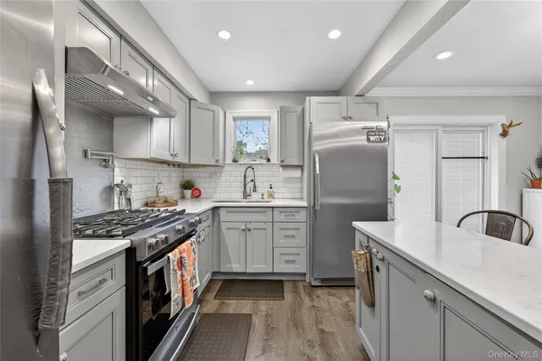a kitchen with granite countertop a sink stainless steel appliances and cabinets