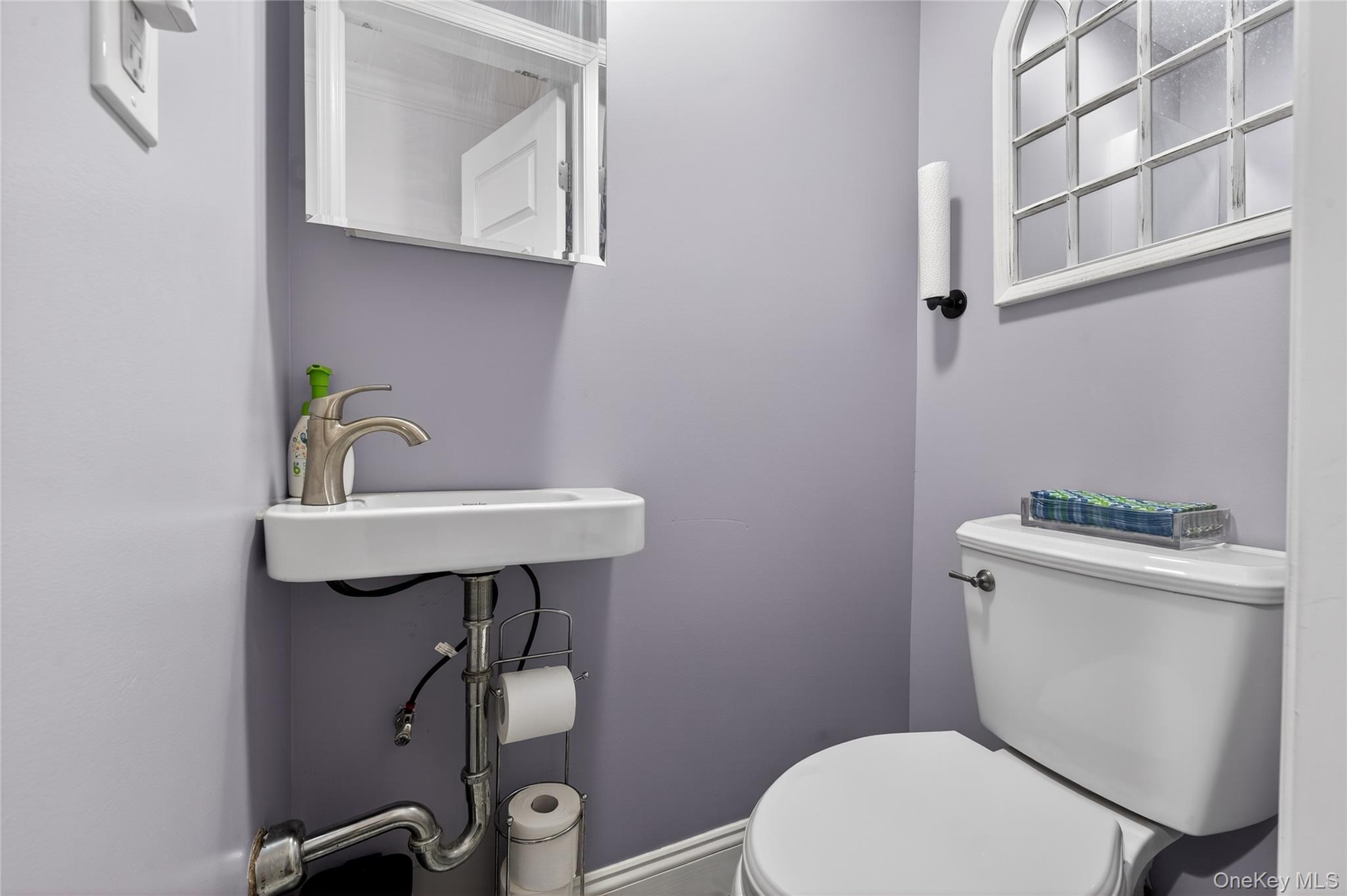 3530 Long Beach Road, Unit 8 Oceanside, NY 11572 - Photo 8 of 19 a bathroom with a sink a toilet and mirror