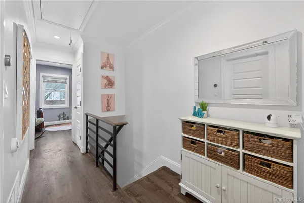 a bedroom with a bed mirror and clock on wall
