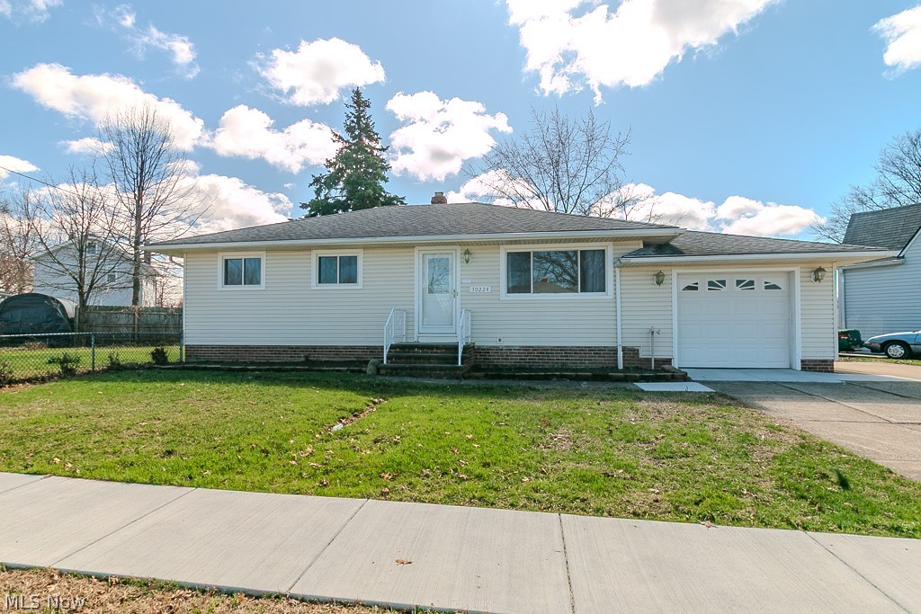 Ranch-style house featuring an attached garage, driveway, a chimney, and entry steps