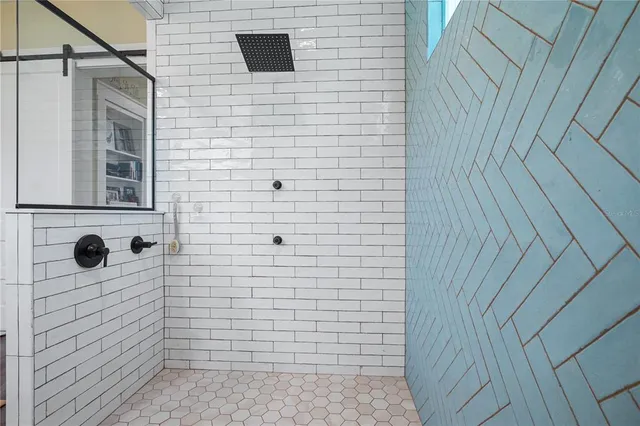 a bathroom with a granite countertop sink a mirror and shower