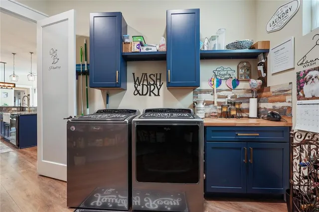 a view of staircase with lots of frames on wall and wooden floor