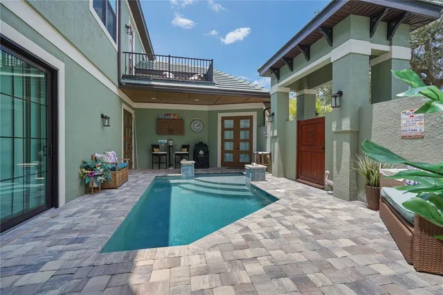 an aerial view of a house with swimming pool and outdoor seating